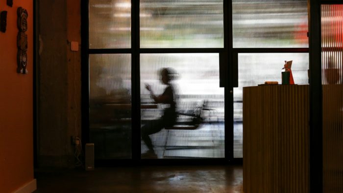 Two people at a table seen through a glassdoor